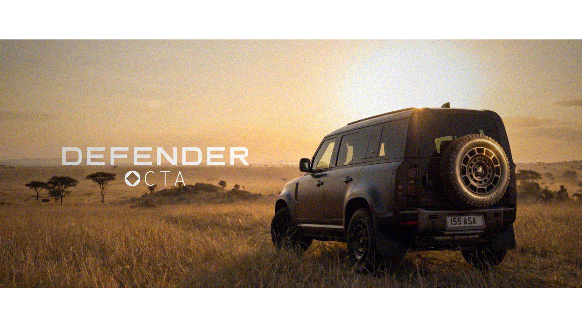 A dark grey Land Rover Defender "Octa" edition parked on a hill on the left of frame, overlooking the Serengeti plains at sunrise, with the Defender Octa logo overlaid to the left.